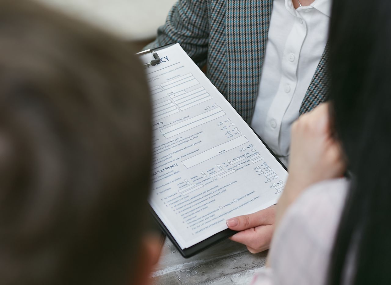 who-we-are-img Close-up of professionals discussing a legal contract during a business meeting.